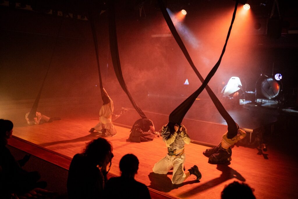 Sorry we didn't respond earlier close stage image with two masked performers