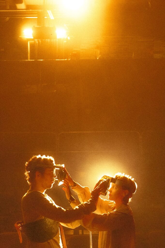 Dark stage image with performers and object